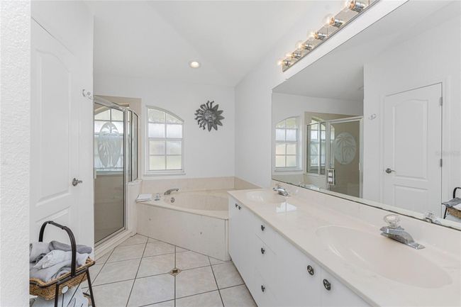 Primary bath has both a garden tub and step in shower with door | Image 24