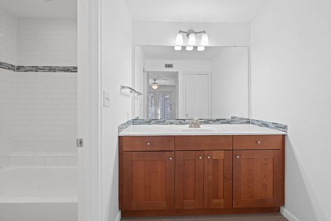 Bathroom featuring vanity, a ceiling fan, visible vents, baseboards, and shower / bathing tub combination | Image 23