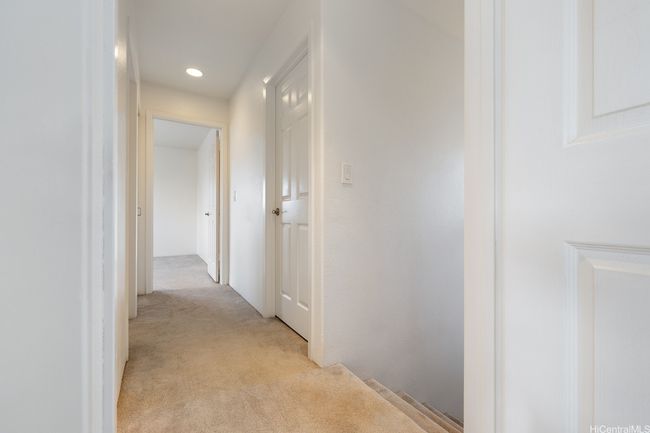 At the top of the stairs is the hallway to the bedrooms. | Image 11
