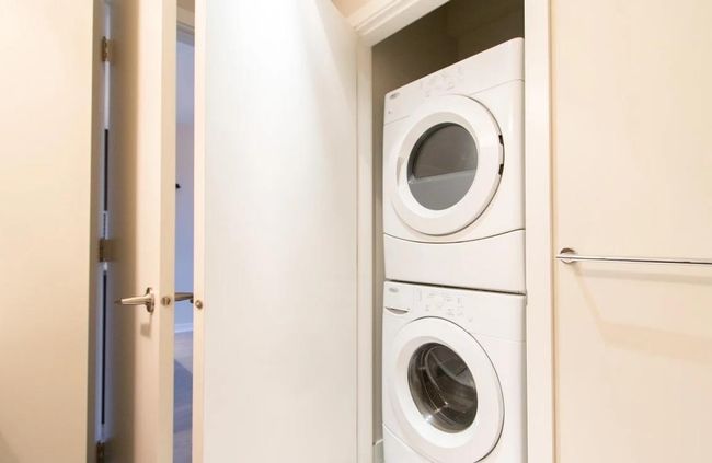 Washroom with stacked washer and dryer and laundry area | Image 15