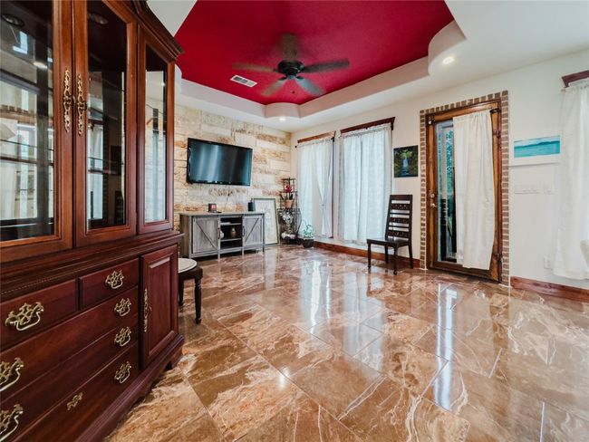 Living room with a raised ceiling, ceiling fan, recessed lighting, and marble tiled floors | Image 16