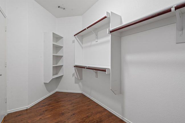 Walk in closet with dark wood-type flooring | Image 17