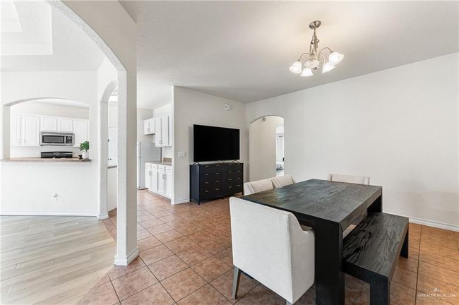 Dining room with arched walkways, a chandelier, and light tile patterned flooring | Image 24