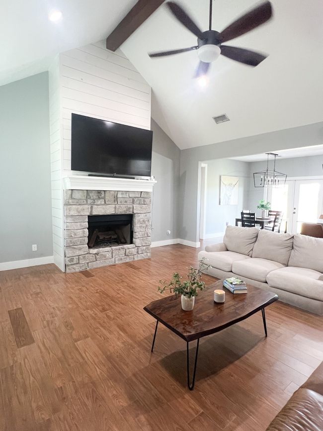 Living room featuring hardwood / wood-style floors, ceiling fan, a fireplace, and beam ceiling | Image 7