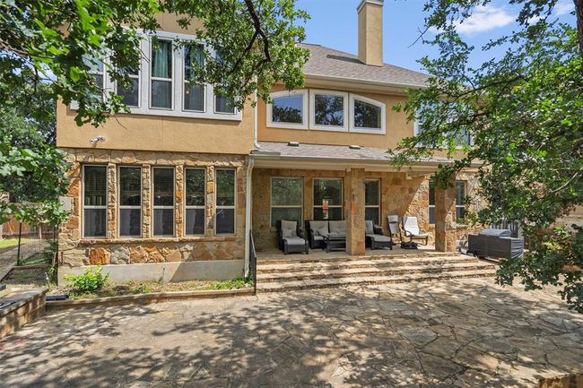 Back of house with stone siding, an outdoor living space, a patio area, and stucco siding | Image 34