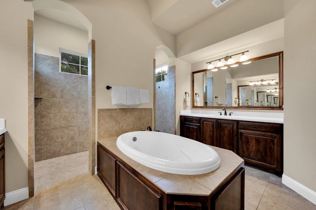 Full bathroom with vanity, a tub with jets, a walk in shower, and tile patterned floors | Image 21