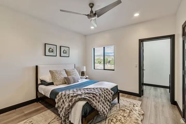Bedroom with light wood finished floors, recessed lighting, a ceiling fan, and baseboards | Image 64