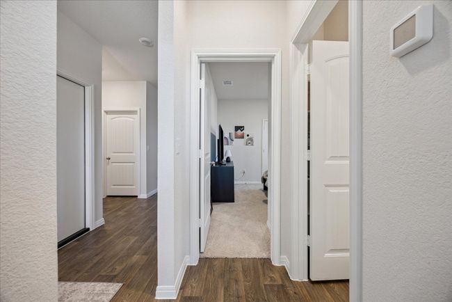 Hall with dark wood-type flooring and a textured wall | Image 24