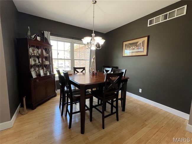 Dining area featuring light wood-style floors and a chandelier | Image 14