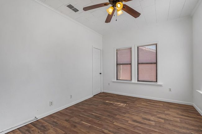 Unfurnished room with dark hardwood / wood-style flooring, ornamental molding, and ceiling fan | Image 31