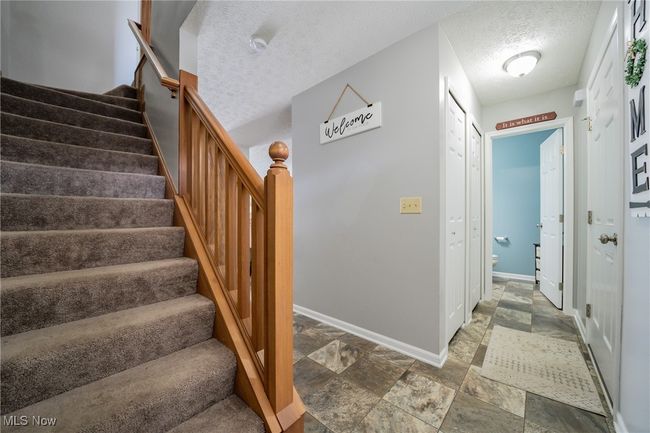 Stairs featuring a textured ceiling and tile patterned floors | Image 4