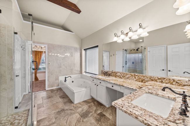 Full bathroom featuring double vanity, a stall shower, a jetted tub, high vaulted ceiling, and beamed ceiling | Image 17