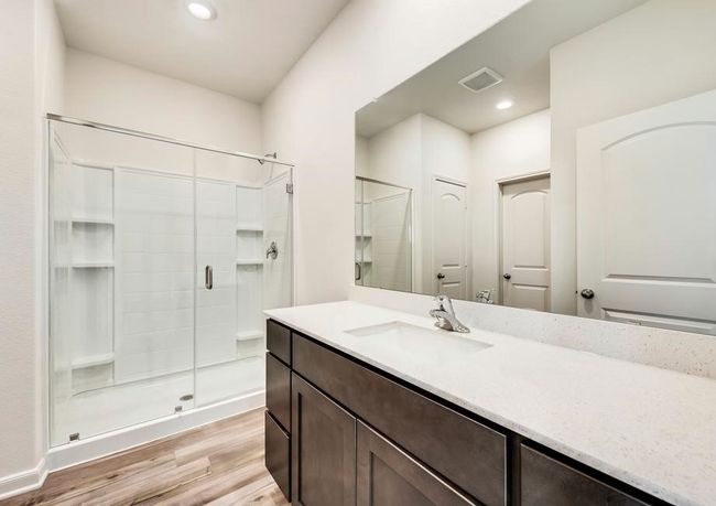 Bathroom featuring visible vents, a stall shower, wood finished floors, recessed lighting, and vanity | Image 7