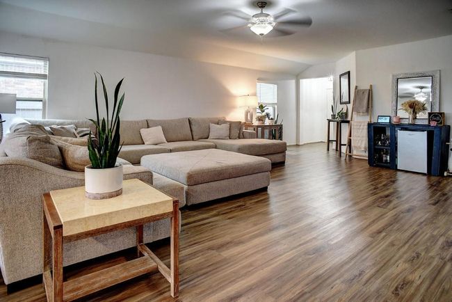 Living room featuring dark wood-type flooring, lofted ceiling, and a ceiling fan | Image 8