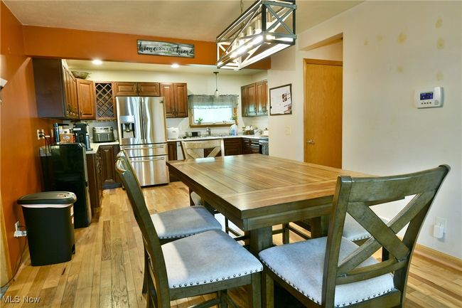 Dining space with light wood-style flooring and baseboards | Image 8