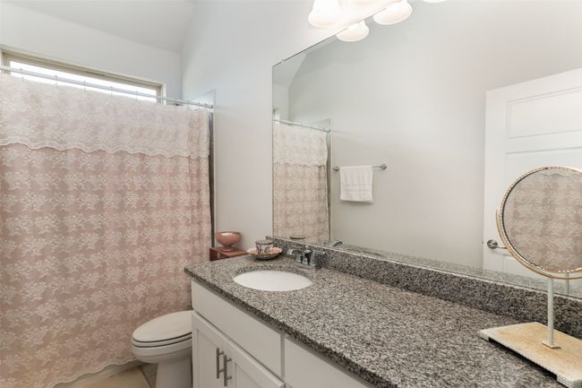 Full bath with a shower with shower curtain, toilet, and vanity | Image 33