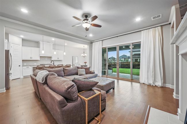 Living area featuring ceiling fan, light wood-style flooring, ornamental molding, and recessed lighting | Image 11