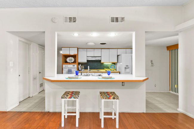 Sleek kitchen seamlessly flows into the inviting living room. | Image 13