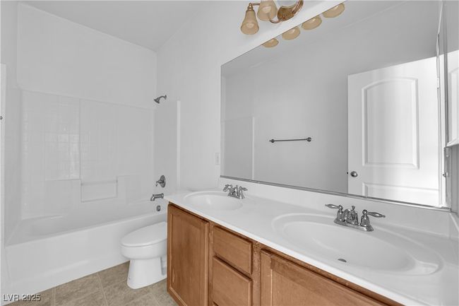 Full bathroom featuring toilet, washtub / shower combination, a sink, and double vanity | Image 15