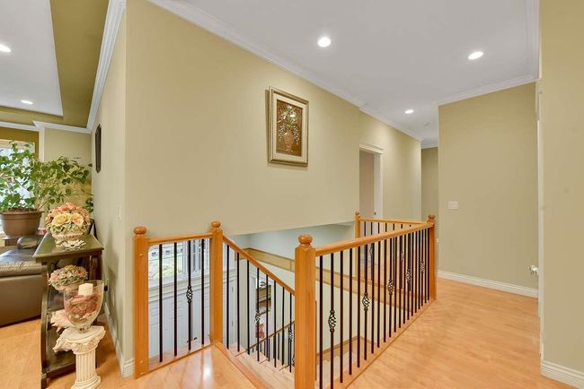 Hall featuring ornamental molding, an upstairs landing, wood finished floors, healthy amount of natural light, and baseboards | Image 37