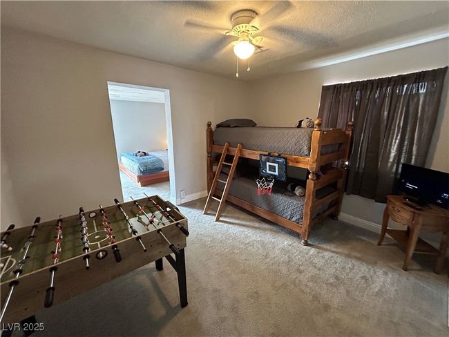 Carpeted bedroom with a textured ceiling and ceiling fan | Image 18