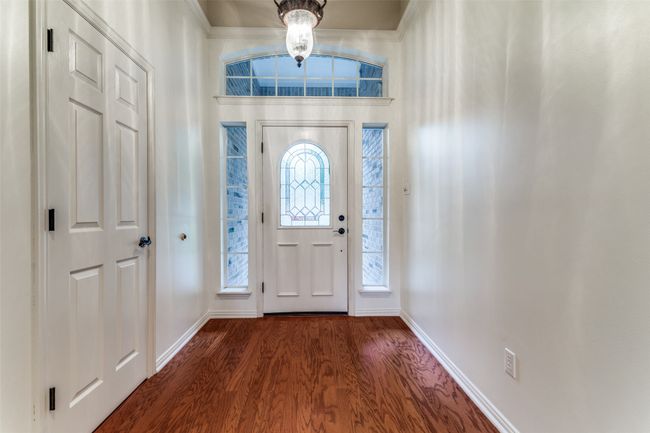 Foyer entrance with baseboards, dark wood-style flooring, and a chandelier | Image 4