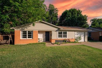 Single story home with a garage and a lawn | Image 1