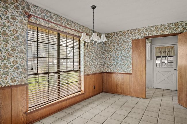Unfurnished dining area with a wainscoted wall, wallpapered walls, a chandelier, and a healthy amount of sunlight | Image 10