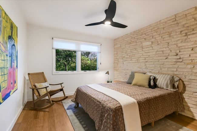 Bedroom featuring texas limestone wall and window to the backyard | Image 21