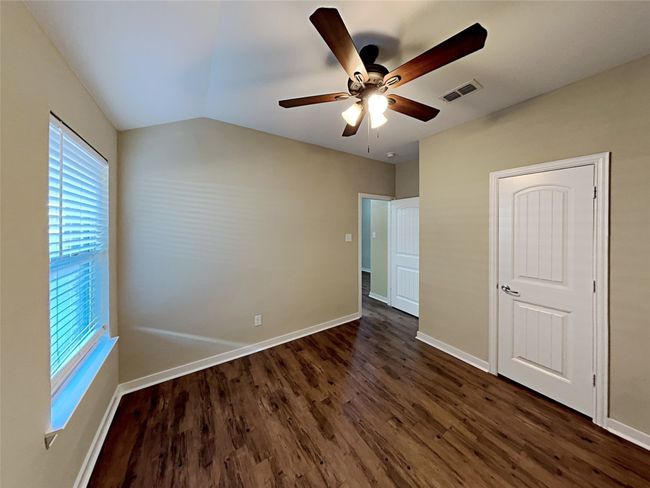 Unfurnished bedroom with dark wood-style floors, a ceiling fan, and lofted ceiling | Image 4