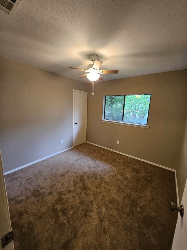 Empty room with a ceiling fan, carpet floors, a textured ceiling, visible vents, and baseboards | Image 26
