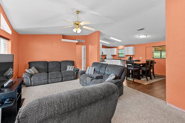 Living room with vaulted ceiling, healthy amount of natural light, ceiling fan | Image 6
