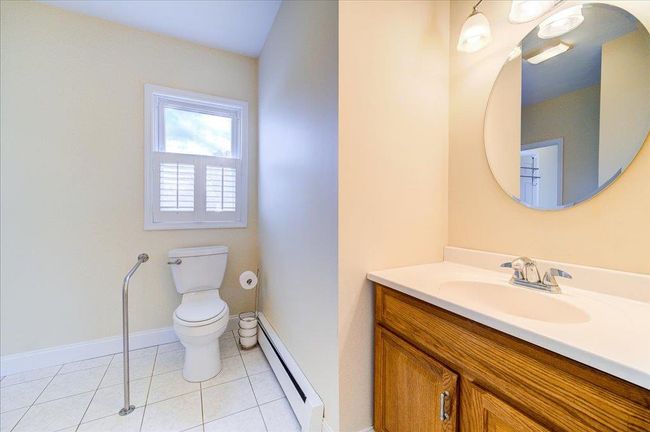 Bathroom featuring vanity, baseboard heating, baseboards, tile patterned flooring, and toilet | Image 15
