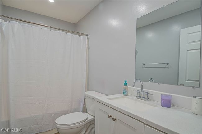 Full bathroom with toilet, vanity, and shower / bath combination with curtain | Image 15