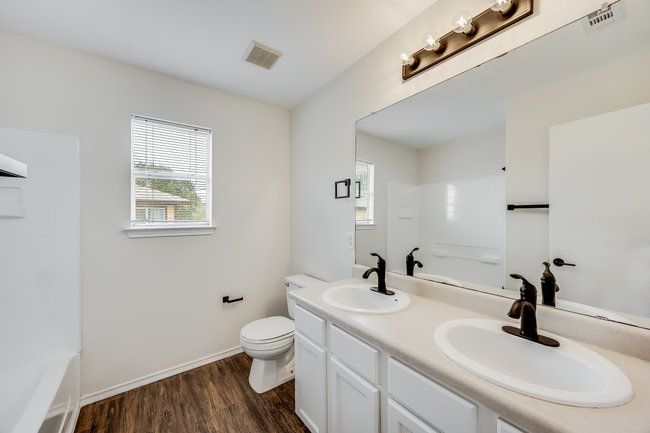 Full bath featuring double vanity, toilet, wood finished floors, and baseboards | Image 28