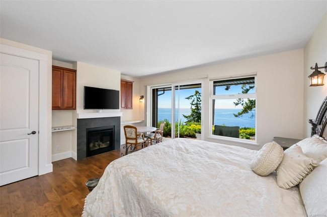 Bedroom with dark wood finished floors and a glass covered fireplace | Image 63