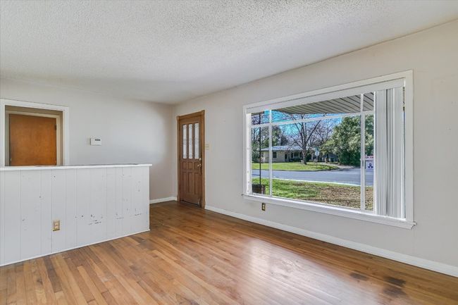 Unfurnished room with a textured ceiling, baseboards, and hardwood / wood-style flooring | Image 4