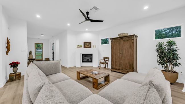 Living room featuring a glass covered fireplace, light wood-style flooring, ceiling fan, and recessed lighting | Image 13