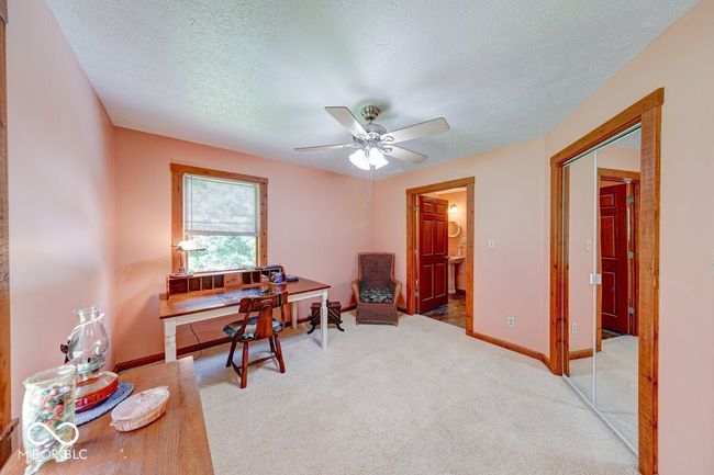 office space featuring ceiling fan, carpet floors, and a textured ceiling | Image 32