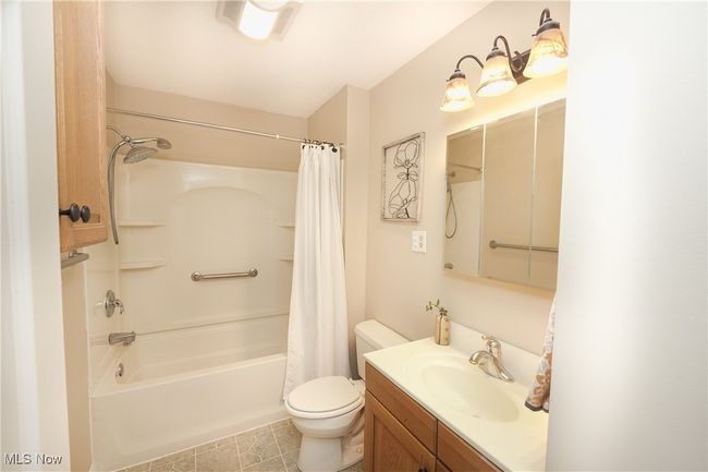 Full bathroom with shower / tub combo with curtain, toilet, vanity, and tile patterned floors | Image 25