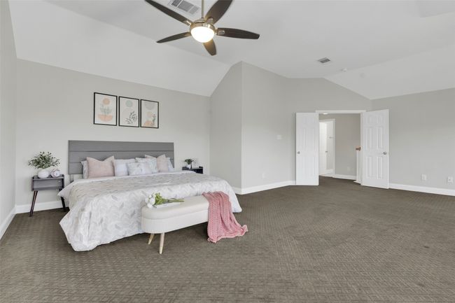 Carpeted bedroom with vaulted ceiling and a ceiling fan | Image 26