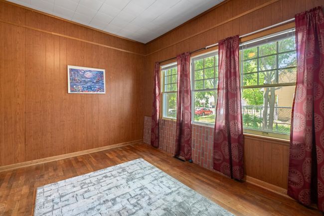 Unfurnished room with plenty of natural light, wood finished floors, wooden walls, and baseboards | Image 16