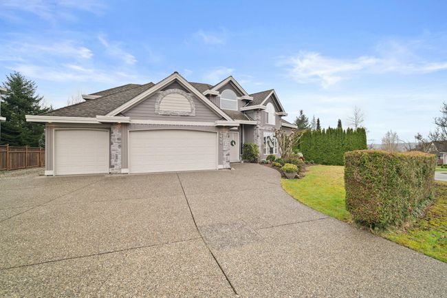 Traditional home featuring driveway, a shingled roof, a garage, and fence | Image 36