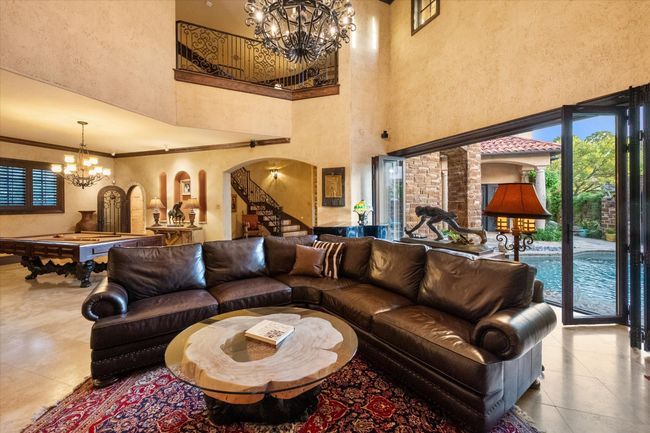 Living room with a chandelier, arched walkways, a high ceiling and travertine floors | Image 9