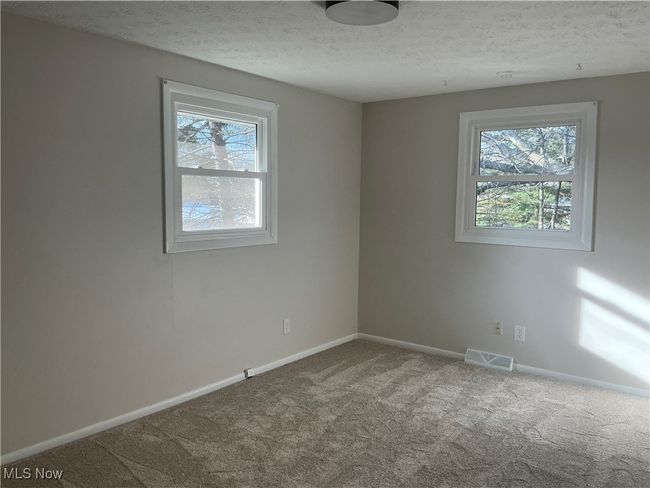 Empty room with carpet flooring, plenty of natural light, and a textured ceiling | Image 9