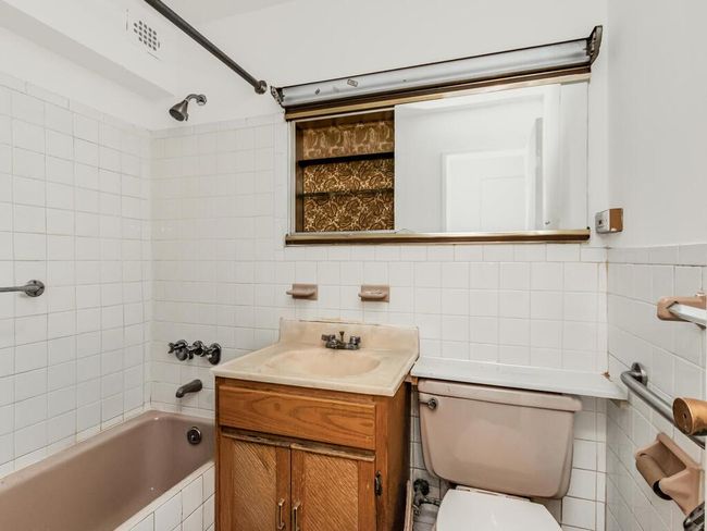 Bathroom with vanity, shower combination, tile walls, and toilet | Image 6