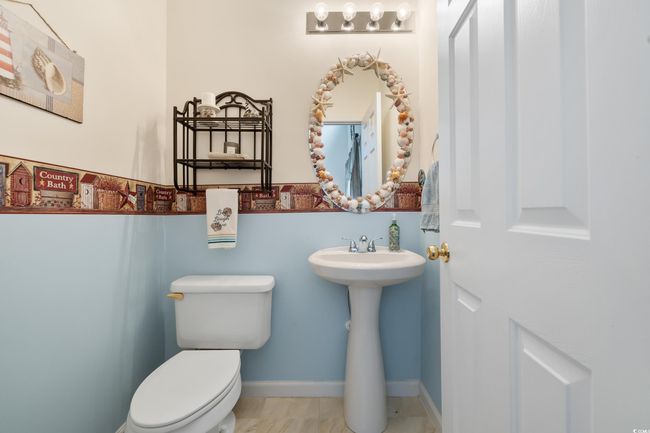 Half bathroom with toilet, a sink, and baseboards | Image 32