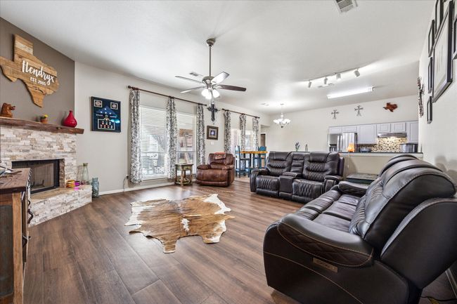 Open-concept living area seamlessly connected to the kitchen and dining space, perfect for entertaining and everyday living. | Image 6