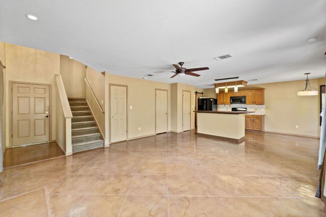 Unfurnished living room with a ceiling fan, stairway, and recessed lighting | Image 9