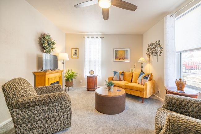 Carpeted living room featuring ceiling fan, healthy amount of natural light, and baseboards | Image 7